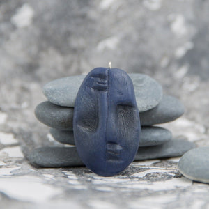 Blue two faced tribal pendant from polymer clay in neutral grey background
