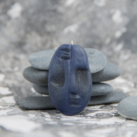 Blue two faced tribal pendant from polymer clay in neutral grey background
