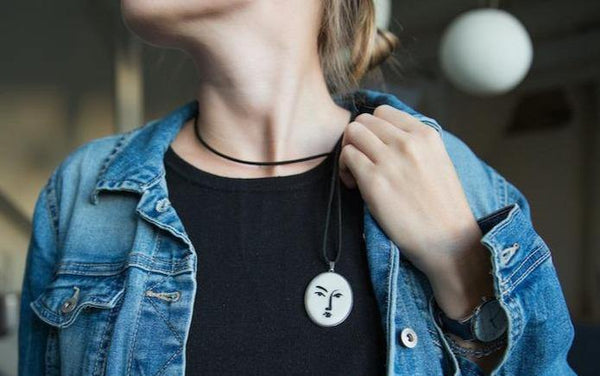 girl with blue jeans jacket showing white handmade necklace