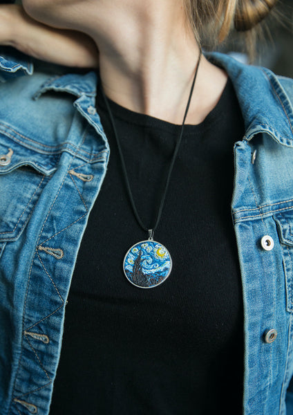 Cropped photo of girl demonstrating how round Starry Night necklace looks like on black shirt and blue jean jacket