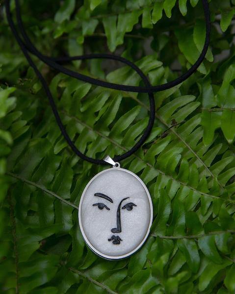 white with black lines necklace inspired by Matisse art on green fern background 