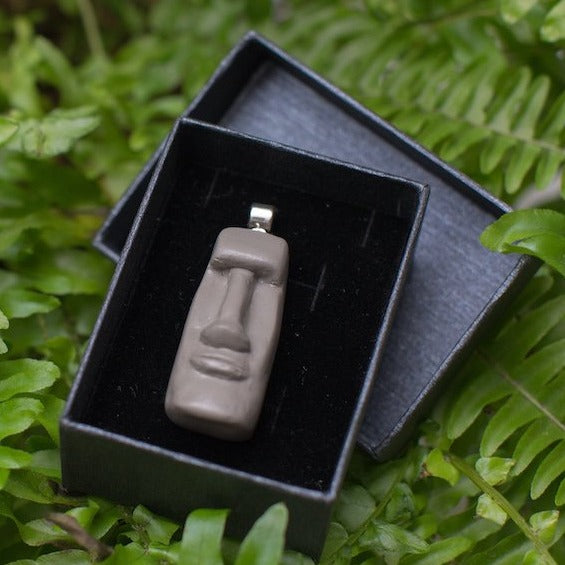 Easter Island statue style pendant in balck gift box on green fern background