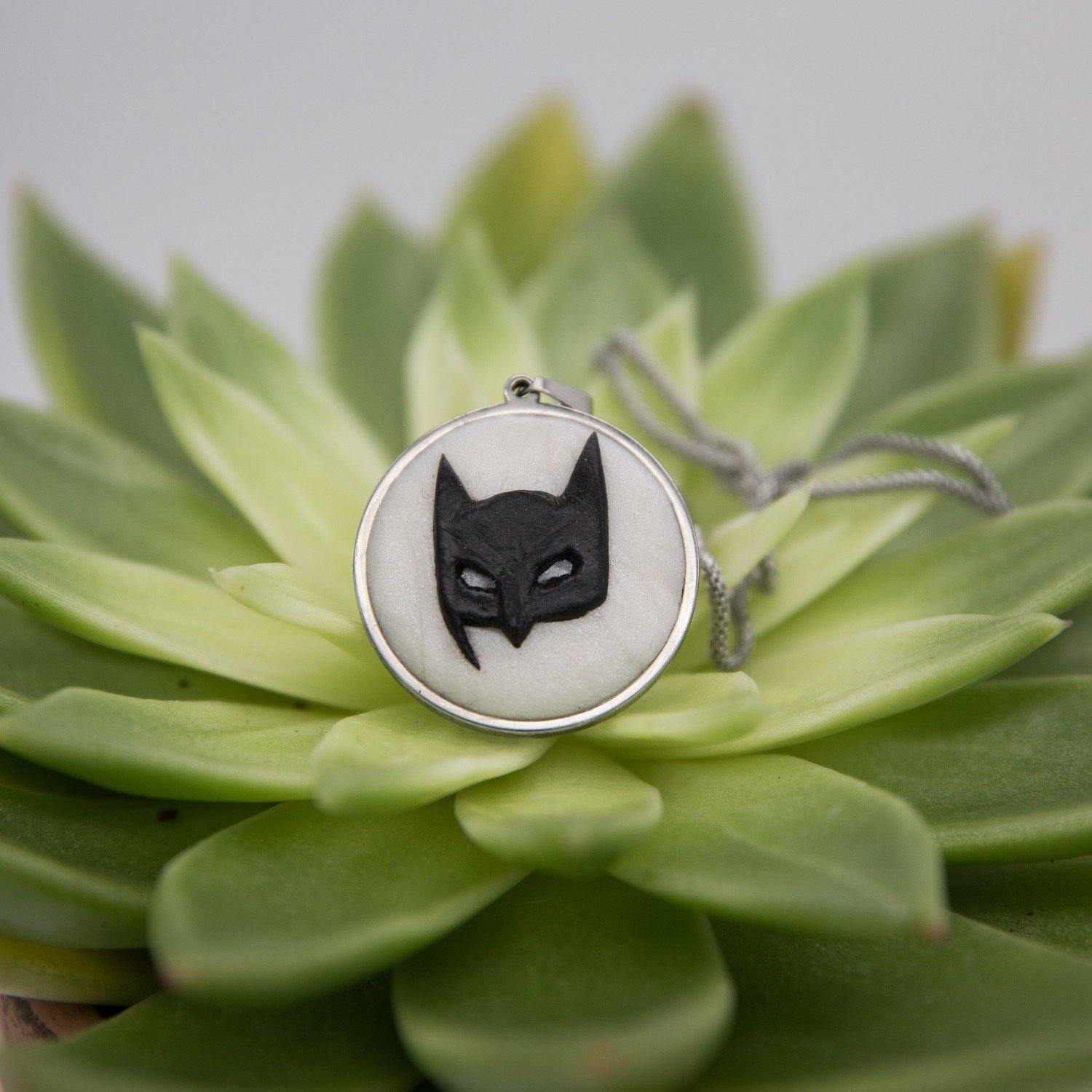 Stainless steel cabochon with handsculpted polymer clay batman mask in green succulent background