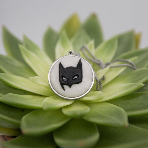 Stainless steel cabochon with handsculpted polymer clay batman mask in green succulent background