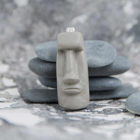 Moai style grey pendant in neutral grey background with grey stones